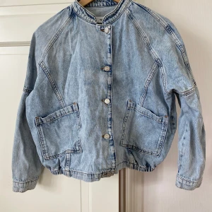 Ljusblå jeansjacka från MNG Denim - Säljer en ljusblå jeansjacka från MNG Denim i 100% bomull. Jackan har oversized passform, stora fickor framtill, knäppning med knappar och elastisk nederkant. Perfekt för dig som gillar en avslappnad och cool look.