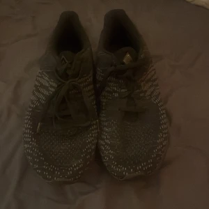 Svarta sneakers med mönster - Snygga svarta sneakers med vita stickade detaljer och snörning. Skorna har en rund tå och platt sula, perfekt för dig som gillar en sportig och modern look. Ovandelen är i syntetmaterial med ett coolt mönster som sticker ut.