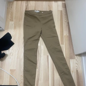 Beiga skinny byxor från H&M L.O.G.G. - Snygga beiga byxor från H&M L.O.G.G. i storlek 38. De har en tight passform med hög midja och dragkedja i sidan. Byxorna är gjorda i bomull och har en klassisk, stilren look som passar till det mesta.