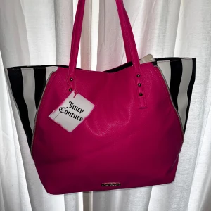 Juicy Couture väska😍(ny) - jättesnygg Juicy Couture väska!💕💕 med svarta och vita ränder på sidorna. väskan har långa handtag, guldfärgade nitar och en designad dragkedja på sidorna för en unik design. helt ny med lapp!😍❣️