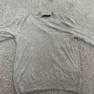 Grå stickad kortärmad tröja  - En basic grå stickad kortärmad tröja från Lager 157 i storlek XS. Tröjan har rund halsringning, korta ärmar och ribbade muddar vid ärmslut och nederkant. Har bara använt den max 2 ggr. 