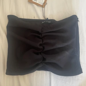 Svart tubtopp från Bershka S - Svart tubtopp från Bershka i storlek S.    Aldrig använd men går säkert att använda som en kortkjol också! 💖
