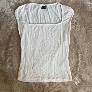 Ljusrosa topp från Gina Tricot - Säljer en ljusrosa topp från Gina Tricot i storlek XXS. Den har 2 gråa fläckar men som bara syns lite i starkt ljus , se bild.