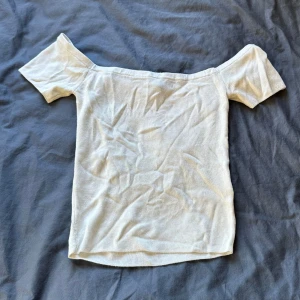 Vit offshoulder topp från Divided hm - Säljer en vit ribbad offshoulder topp från Divided hm i storlek S. Mjukt material och väldigt bekväm. Skriv om du önskar bild med plagget på och pris kan diskuteras!