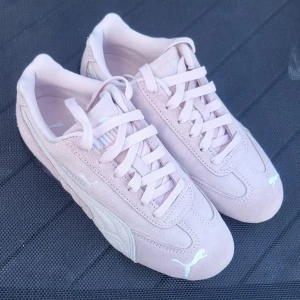 Rosa Speedcats -  Ljusrosa Speedcat sneakers från Puma i mjuk mocka med vita detaljer och svart sula. Klassisk låg modell med snörning och rund tå. Storlek 36. Helt nya med originalkartong.