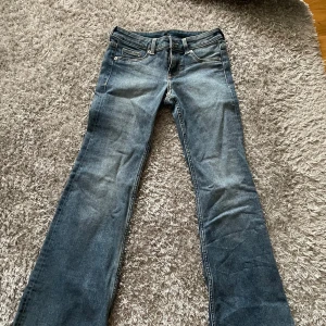 Blå low waist bootcut jeans från H&M - Snygga blå low waist jeans från H&M med klassisk bootcut-passform. Det är dock korta i benen. Jeansen har fem fickor, låg midja och är tillverkade i slitstarkt denim. Det är använda endast en gång.