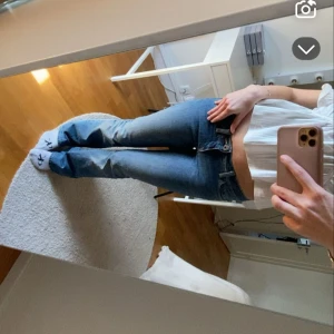 Blå bootcut jeans med låg midja - Snygga blå jeans med bootcut-modell och låg midja. Jeansen har klassisk femficksdesign och cool diamantformad detalj på bakfickan. Tillverkade i jeansmaterial med lätt slitning för en avslappnad vibe.