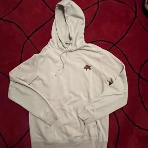 Beige hoodie med ros- och ormmotiv - Snygg beige hoodie med huva och snörning. 