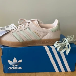 OANVÄNDA Adidas Gazelle Indoor W pastell - HELT OANVÄNDA adidas gazelle strl 38 2/3 Ljusrosa med mintgrön och ljusbrun sula. Säljer pga fel storlek och då jag inte kunde skicka tillbaka. Skriv gärna om du har frågor eller vill ha fler bilder! 💗💚💛