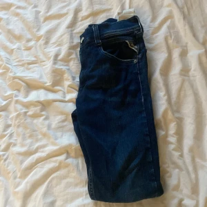 Mörkblå jeans från Replay - Snygga mörkblå jeans från Replay med klassisk femficksdesign och diskreta slitningar. Jeansen har raka ben och normal passform, perfekta till vardagslooken. Materialet är mjukt och stretchigt jeans, vilket gör dem riktigt bekväma. Skriv vid frågor eller funderingar😃 pris kan diskuteras🤙🏼