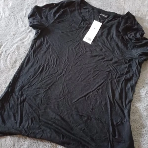 Svart t-shirt Elin top M - Enkel svart t-shirt från gina tricot i modellen Elin top. Klassisk rund halsringning och korta ärmar, perfekt basplagg till garderoben. Mjuk och skön känsla, passar till allt och är lätt att matcha.