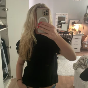 Svart topp med volangärmar - Säljer en svart topp med korta volangärmar och ribbad nederkant. Modellen är lite loose. Så snyggt till jeans eller jeanskjol. Säljer lite dyrare då jag köpte den dyrt, ifrån sellpy märket är yas!
