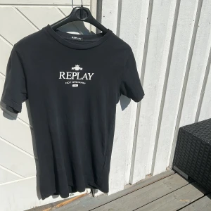 Svart Replay t-shirt med tryck - Säljer denna stilren t shirten ifrån replay. Storlek S. Den har inga hål eller difekter. Pris kan diskuteras vid snabb affär!!