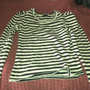 Svartvit randig långärmad tröja Gina Tricot - Svartvit långärmad tröja från Gina Tricot i storlek XS. Tröjan har klassiskt horisontellt randigt mönster och är gjord i mjuk bomull. Perfekt för dig som gillar enkel och stilren look med lite edge. Rund halsringning och normal passform.