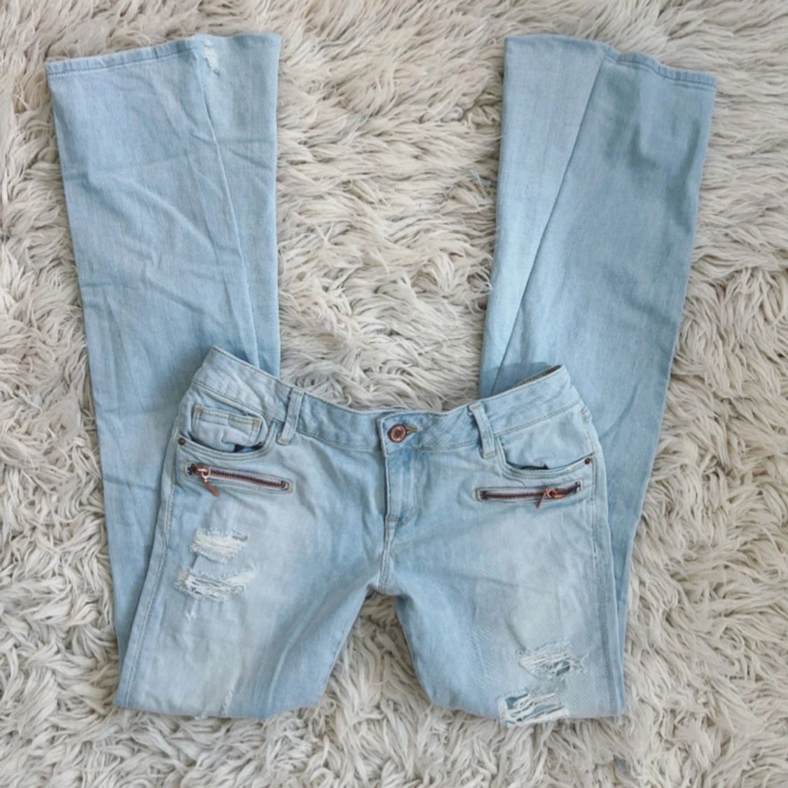 Lågmidjade ljusblåa bootcut jeans med slitningar