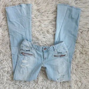 Lågmidjade ljusblåa bootcut jeans med slitningar  - SKRIV INNAN NI KÖPER!!! Sååå snygga! Midja: ca 40 cm rakt över💕innerben: ca 84 cm💕 Utsydda till bootcut själv (har gjort det flera gånger innan) skriv för mer bilder/ info på hur de är sydda💕