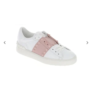 Valentino Rockstud Open sneakers vit/rosa - Säljer ett par Valentino Rockstud Open sneakers i vitt skinn med ljusrosa band och ikoniska nitar över vristen. Snygg, rund tå och platt sula. Skorna har snörning och en clean, modern look som sticker ut med sina coola detaljer.