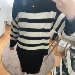 Svartvit randig stickad tröja - Säljer en snygg stickad tröja med breda svarta och vita ränder. Tröjan har en relaxed passform, rund hals och långa ärmar. Från GinaYoung i storlek 134/140 men passar bra på mig som har XS.