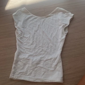 Vit topp från Gina Tricot XXS - Topp från Gina i storlek xxs med öppen rygg. Säljer pågrund av att den är för liten för mig.