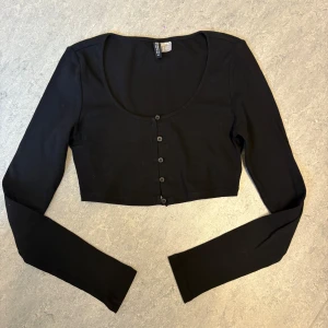 Svart croppad topp från H&M Divided - Svart croppad topp från H&M Divided med lång ärm och rund halsringning. Väldigt bra skick. Pris kan diskuteras
