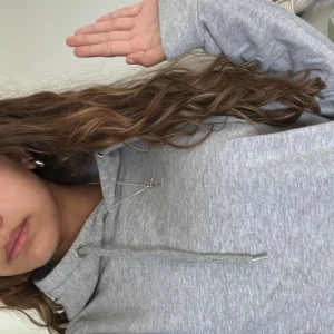 Grå hoodie  - Säljer en enkel och chill grå hoodie med huva . Tröjan har lång ärm och är gjord i mjukt bomullsmaterial, perfekt för att slänga på sig när man vill vara bekväm. Passar dig som gillar en clean och avslappnad stil.