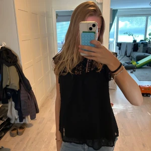 Svart blus med spets och volang - Säljer en svart blus dem är skit fin på och älskar hur den sitter på. Har inte använt den så mycket nästan helt ny 
