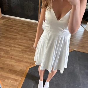 Vit kort klänning / studentklänning - Supersöt vit klänning. Baksidan är öppem och dekorerad med vacker spets. Perfekt för student eller sommarens alla tillfällen! Prislapp kvar på💕