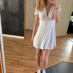 Chelsea klänning - Supersöt vit kort klänning från Chelsea med broderade spetsdetaljer. Passar till studentklänning