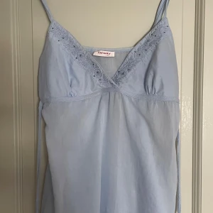 Ljusblå cami top  - En unik top från märket Orsay som är köpt på vinted. Den har broderi detaljer och små paljetter, och går att knyta i ryggen för en tajtare passform. Den har även en dragkedja i sidan ✨🪩Hör av dig om du har frågor eller är intresserad! ☺️
