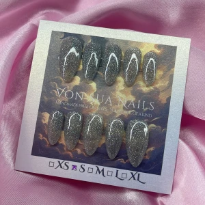 Glitter (S);Medium Almond - Snygga handgjorda press-on naglar med silvrigt glitter och vita detaljer. Naglarna har en medium almond-form och kommer i S: 15 mm, 11,5 mm, 12 mm, 11 mm, 9 mm . Perfekt för dig som vill ha en glam look med extra edge.