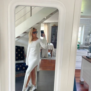 Vit lång stickad klänning NA-KD - Supersnygg lång stickad klänning från NA-KD i vit ton med glittriga detaljer. Modellen har lång ärm, rundad hals och en hög slits på sidan som ger en cool vibe. Materialet är mjukt och stretchigt, perfekt för dig som gillar att sticka ut. Sparsamt använd och i fint skick. Säljer klänningen pga för lite tyvärr. 