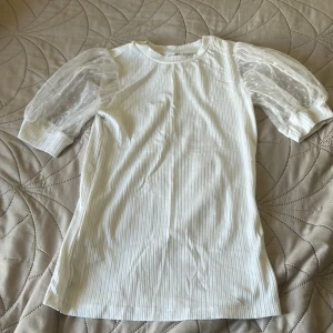 Polka dot Vit ribbad topp med puffärm Reserved XS - Supersöt vit topp från Reserved i storlek XS med ribbad struktur och transparenta puffärmar i mesh med prickigt mönster. 