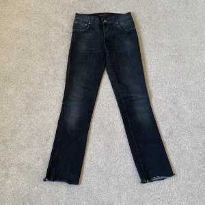 Svarta Nudie Jeans  - Svarta jeans från Nudie Jeans i modellen Slim Jim. Det är tydliga tecken på användning men det gör det bara snyggare! Det finns ingen ”kant” vid byxbenens slut eftersom de blivit borttagna (syns på bild). Skriv gärna vid minsta lilla fråga! 🌟