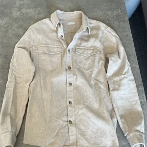 Beige skjorta Tiger of Sweden M - En snygg stilren oanvänd overshirt med riktigt bra passform, storlek M  funkar även för S, bra skick så hör av er!!