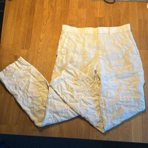 Beige linnebyxor från H&M, Slim Fit - Tjena! Säljer ett par beige linnebyxor från H&M i slim fit-modell. Byxorna har klassiska fickor bak och bälteshällor i midjan. Linnebyxorna är  100% linne vilket gör dem luftiga och perfekta för varmare dagar. Passar dig som gillar stilrena och fräscha vibes. Ändast använda ett fåtal gånger!😁