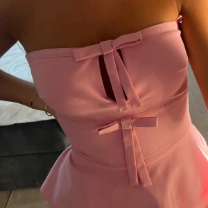 Rosa axelbandslös klänning med rosetter - Supersöt rosa tubtopp köpt från Zara med prislapp kvar🩷