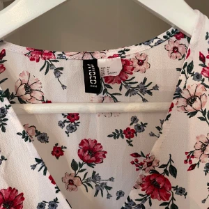Blommig omlottklänning från H&M - omlottklänning med knytband från H&M. Fint skick 