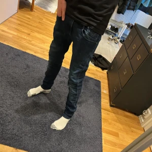 Replay Anbass Jeans - Mörkblåa Replay Anbass Slim fit. Storlek 31:34 (Passar dig med 30 midja). Inga hål, fläckar eller liknande. Väldigt bra skick. Köptes nya förra året. Personen på bilden är runt 180 cm lång.  Tveka inte med att ställa frågor. Skulle säga att de är mindre i längden!! Tveka inte på att ställa frågor!!