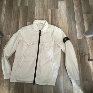 Stone Island Overshirt - Stone Island Overshirt i storlek M. Köpt är Köpt. Bjuder på frakt vid ett smidigt och snabbt köp! Den har pyttesmått hål som hag fotat men det är inget man märker  