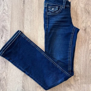 Mörkblå bootcut jeans Gina Tricot Young strl 158 - Mörkblå jeans med fickor bak och fram. Dekorativa sömmar och en knapp på bakfickan. Gina Tricot strl 158 fint skick