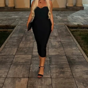 Svart korsett långklänning - Säljer en elegant svart korsettklänning  design och figurnära passform. Klänningen har en stilren och tidlös look som passar perfekt till speciella tillfällen. Materialet känns mjukt och följsamt mot kroppen.