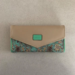 Plånbok - Säljer denna super fina plånbok som är helt oanvänd! Blå och beige på utsidan och en rosa aktig nyans inuti, super bra att ha om man vill ha alla sina kort samlade på ett ställe 😊