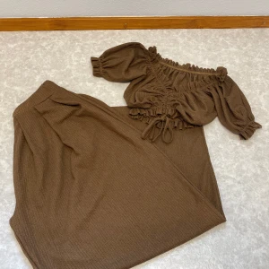 Brun sett  - Säljer en brun byxor och topp med avslappnad passform. Settet har en mjuk och skön känsla, perfekt för dig som gillar en enkel men trendig stil. Matcha med crop top för en snygg look.