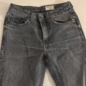 Grå jeans från Tiger of Sweden - Snygga grå jeans från Tiger of Sweden med klassisk femficksdesign och raka ben. Jeansen har en mörkgrå tvätt med subtila slitningar och silverfärgad knapp. Passar dig som gillar stilrena och tidlösa jeans med en modern touch. Storlek 26/32!💞