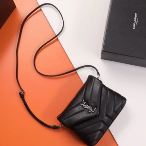 Svart axelväska från Saint Laurent - Snygg svart axelväska från Saint Laurent i quiltat skinn med silverfärgad YSL-logga framtill. Väskan har justerbar axelrem och stilren design som ger en lyxig känsla. Perfekt för dig som vill ha en ikonisk och trendig accessoar.