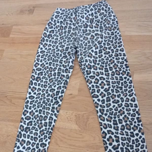 Leopardmönstrade leggings i bomull - Snygga leggings med leopardmönster i svart, brunt och beige. De har en elastisk midja och är gjorda i mjuk bomull, perfekta för dig som vill sticka ut lite extra. Passar till både chill och trendiga outfits.