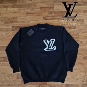 Louis Vuitton Sweatshirt  - Letar du efter en exklusiv designertröja som Exklusiv Louis Vuitton-tröja i svart, storlek M. Nyskick med taggar! Stilren design med den ikoniska LV-loggan i vitt framtill. Tillverkad i mjukt och slitstarkt ullmix-tyg som ger både värme och komfort. Rund hals och ribbstickade muddar för en tidlös finish. Ett lyxigt premiumplagg som fungerar både till vardags och mer uppklädda tillfällen – en riktig investering i garderoben. 📦 Snabb leverans – skickas samma dag!