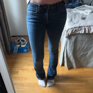 Blå bootcut jeans från Zara - Säljer ett par ljusblåa stretchiga jeans från Zara. De har låg midja och en tight passform. Jag säljer de då jag inte får användning av de. Jag är 163 cm för preferens. Hör gärna av dig vid frågor🤎