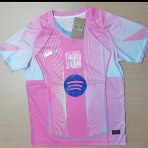 Barça x Nike rosa fotbollströja S - Barcelona x Nike fotbollströja i rosa och ljusblå toner med vita linjer och blått Spotify-logo på bröstet. Kortärmad, rund hals med turkos kant. Materialet är lätt och andas, perfekt för match eller träning. Snyggt grafiskt mönster och klubbmärke på bröstet.