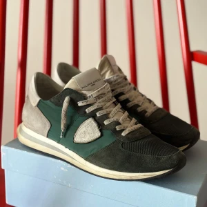 Philippe model trpx  - Snygga sneakers från Philippe Model i mörkgrönt och grått med detaljer i mocka och mesh. Skorna har vita snören med tryckt text och en klassisk logga på sidan. Skorna kan tvättas innan jag skickar iväg de och det är bara att höra av sig vid frågor 